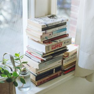 assorted-title book lot beside window